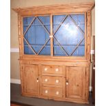 A pine dresser with pier top, fitted two shelves enclosed two glazed doors over three drawers