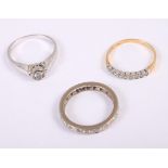 A white metal and diamond eternity ring, size N, a 9ct gold and diamond nine-stone dress ring,