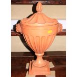 *An antique style terracotta urn and cover with lion mask handles, 18" high