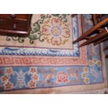 A Chinese contour pile rug decorated central medallion and floral designs in shades of blue on a