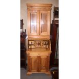 A stripped pine roll top bureau bookcase, the upper section enclosed glazed doors over fitted