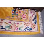 A Chinese rug decorated central medallion and floral design on a yellow ground, 108" x 69" approx