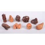 Nine carved hardwood netsuke, in the form of various animals with black glass eyes