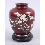 A 20th century cloisonne squat baluster vase, decorated prunus blossoms on a dark red ground, and