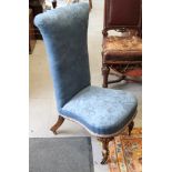 A 19th century walnut prie-dieu, upholstered in blue velvet, on cabriole castored supports