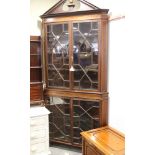 A mahogany and satinwood banded corner cabinet, with broken pediment, over a lattice glazed door,