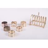 Six silver napkin rings and a silver toast rack, 6.7oz troy approx