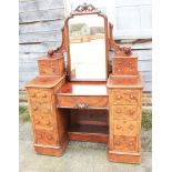 A burr walnut dressing table with swing mirror, flanked four small drawers, above eight short