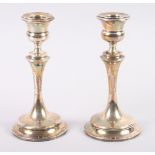 A pair of filled silver pillar candlesticks, on weighted bases, 7" high
