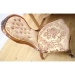 An oak framed nursing chair, upholstered in a floral fabric, on cabriole and ceramic castored