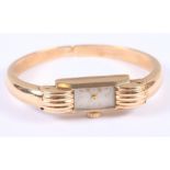 A lady's 9ct gold cuff watch with silvered dial and baton and Roman numerals, 17.7g gross
