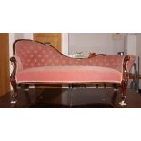 A late Victorian carved walnut showframe chaise longue, upholstered in a pink velour, on cabriole