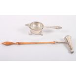 A silver tea strainer and stand, 3oz troy approx, and a silver candle snuffer with turned wooden