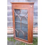 A mahogany corner display cabinet with arched moulding and three shelves enclosed glazed door, 25"