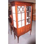 An Edwardian mahogany and inlaid display cabinet, fitted two part glazed doors, on cabriole