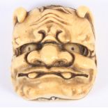 A Japanese Meiji period carved ivory mask Netsuke, Oni to the front, Okame to the back, 2" high