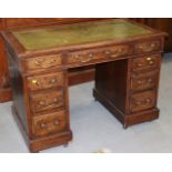 An oak double pedestal desk with tooled lined top, fitted nine drawers, 42" wide x 24" deep x 30"