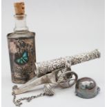 A miniature white metal model of a cannon, a silver scent bottle cap and a silver perfume bottle