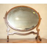 A 19th century walnut oval swing frame toilet mirror, on skeleton stand, 26" wide x 23" high x 10