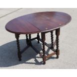 An oak gate leg dining table, on barley twist supports, top 35" wide x 48" wide when open