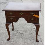 A well reproduced walnut lowboy with quarter veneered top, fitted one long and two small drawers, on