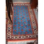 A Caucasian wool geometric design rug with central decoration of fourteen rows of five guls on a red