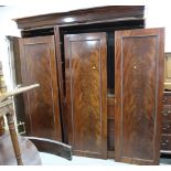 A mid Victorian figured mahogany wardrobe enclosed three panelled doors and fitted interior of two