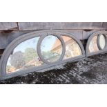 A pair of grey painted lunette mirrors with central circular panel, 51 1/2" wide x 19" high
