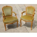 A pair of Louis XVI design polished beech open armchairs, upholstered in an old gold velour