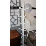 A white painted hat stand, on tripod splay supports