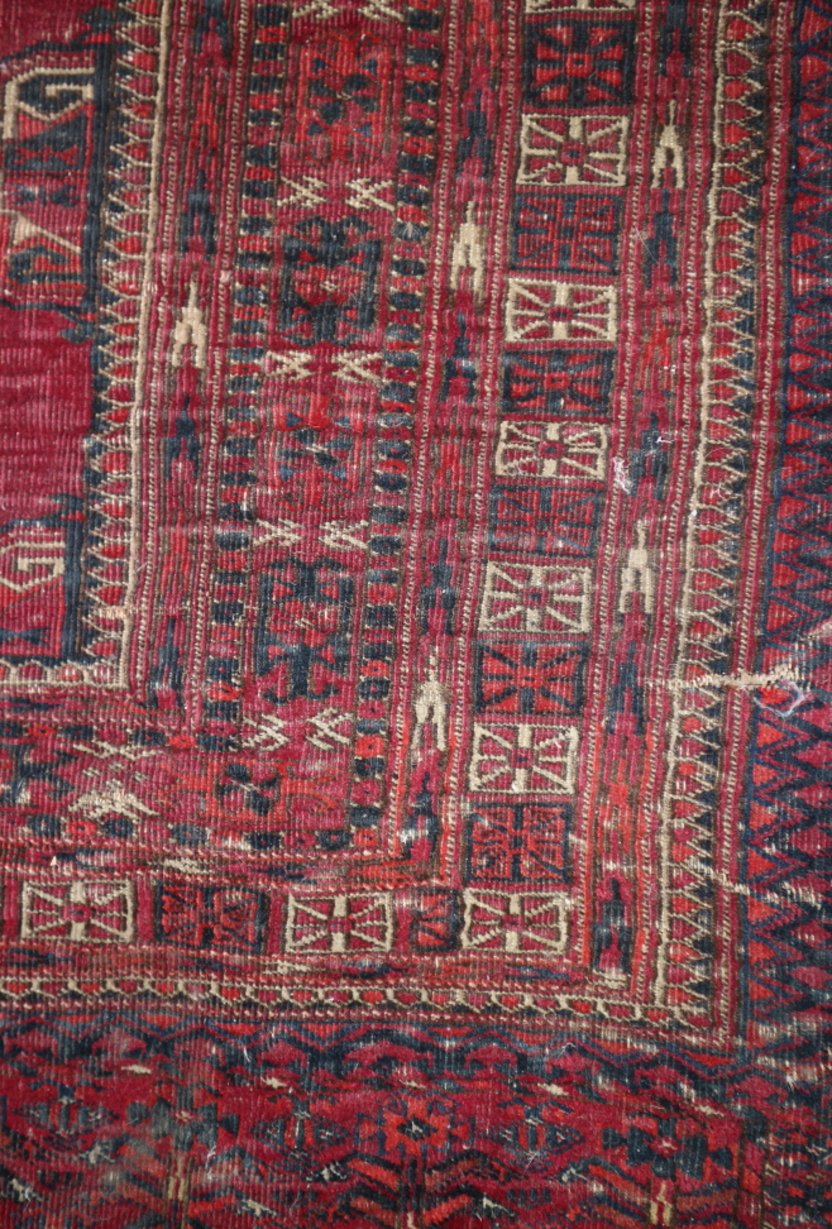 A Bokhara bag face rug with nine octagonal guls in traditional colours, 60" x 30" approx (worn) - Image 3 of 3