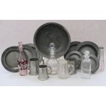 A pewter bowl, seven antique pewter plates, various, three pewter tankards, three glass decanters