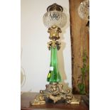 A Victorian oil lamp with green glass column and clear glass reservoir (now converted to