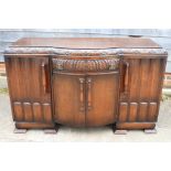 An oak breakfront sideboard, fitted central drawer over cupboards, on bracket feet, 60" wide x 37"