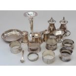 Seven silver napkin rings, various, a silver pin dish, various silver condiment pots and a silver