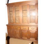 An oak bookcase with pier top, four glazed doors above four drawers and four cupboards, on bracket