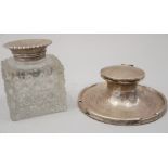 A cut glass inkwell with silver lid and silver capstan inkwell