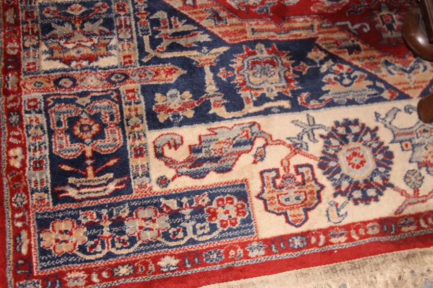 A Middle Eastern wool rug with central medallion, gulls and multi-guard borders on a red ground with