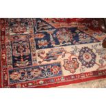 A Middle Eastern wool rug with central medallion, gulls and multi-guard borders on a red ground with