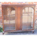 A 1930s figured walnut display cabinet enclosed two lattice glazed doors, on cabriole supports,