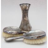 A silver trumpet vase and a pair of silver-backed hair brushes