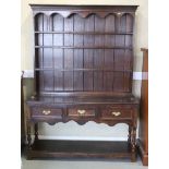 An oak dresser of 17th century design with shelves over three drawers and pot board, 52" wide x