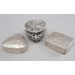A silver trinket box with embossed decoration and two modern silver pill boxes with engraved