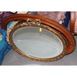 An oval gilt framed mirror with ribbon motif, an oval mahogany framed mirror and another