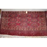 A Bokhara bag face rug with nine octagonal guls in traditional colours, 60" x 30" approx (worn)