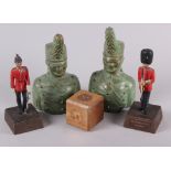 A painted metal model of a Coldstream guard, on wooden stand, another similar, a wooden paperweight,