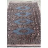 A Bokhara rug with four panels on blue ground, 49" x 69" approx (worn)