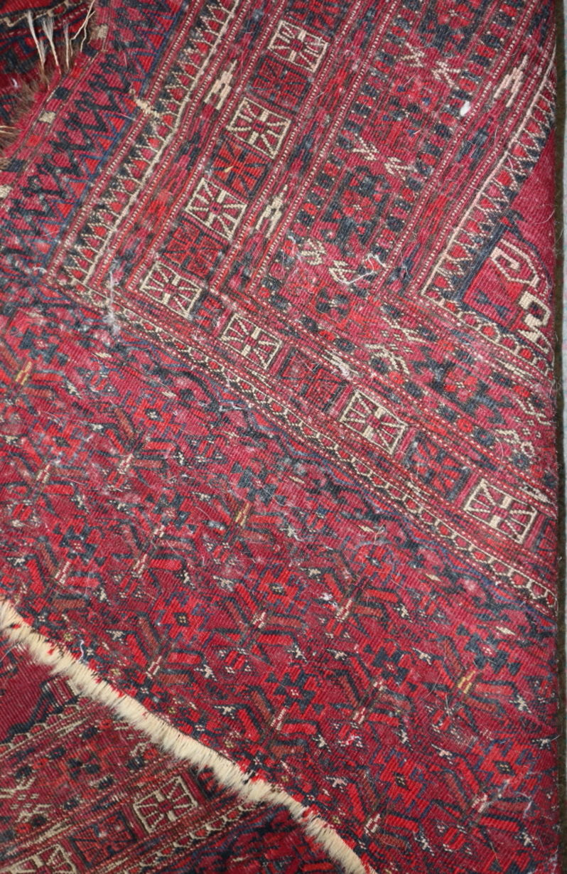 A Bokhara bag face rug with nine octagonal guls in traditional colours, 60" x 30" approx (worn) - Image 2 of 3