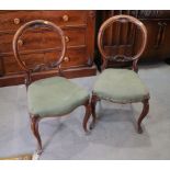 A pair of Victorian carved walnut loop back side chairs with stuffed over seats, on cabriole