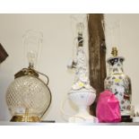A cut glass and brass spherical table lamp with a floral relief decorated table and one other